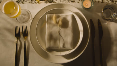 Overhead-Of-Table-Setting-With-Plate-Napkin-Cutlery-And-Glass-Of-Champagne
